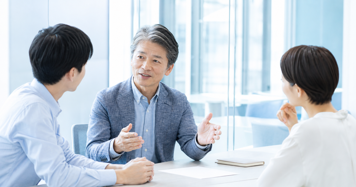 若手にアドバイスをする60代の男性